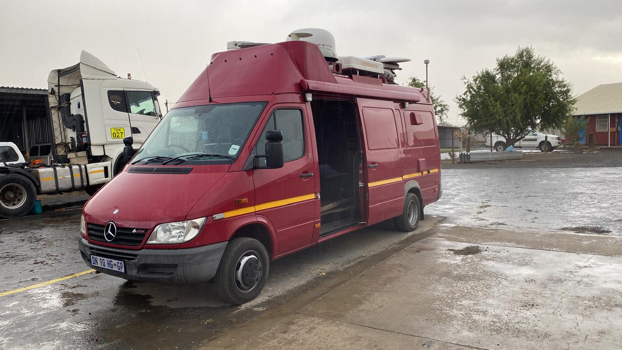 Mojapele satellite news gathering van with roof-mounted antenna, on location in the rain